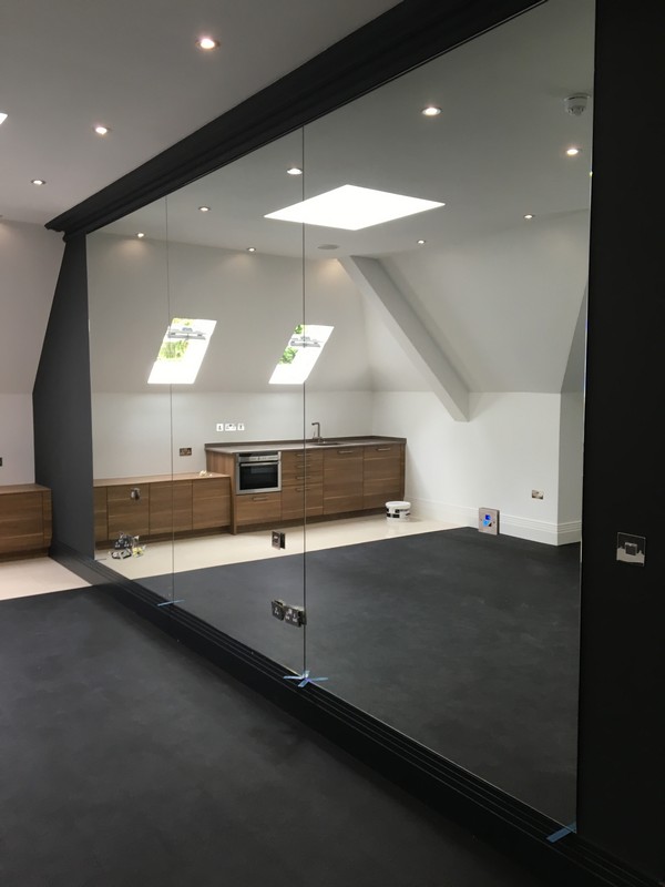 Frameless glass partition in loft conversion by Stockwell glaziers